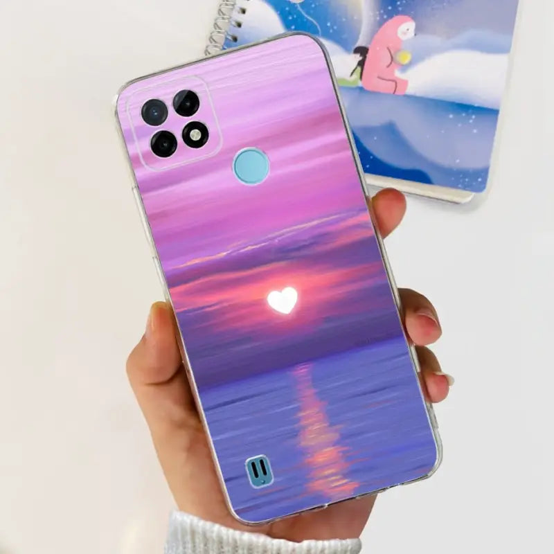 a person holding a phone with a sunset painting on it