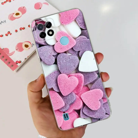 a person holding a phone with pink and purple hearts