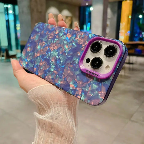 a woman holding a phone case with a purple and blue marble pattern