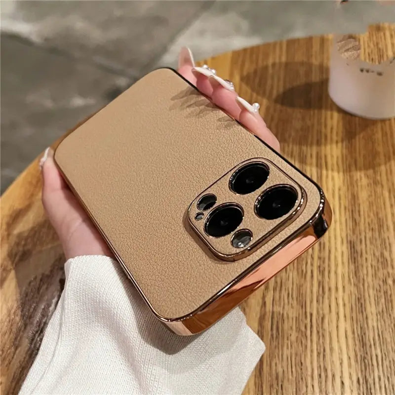 someone holding a gold case with two black buttons on it
