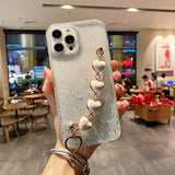 a woman holding up a phone case with a white and silver glitter phone case