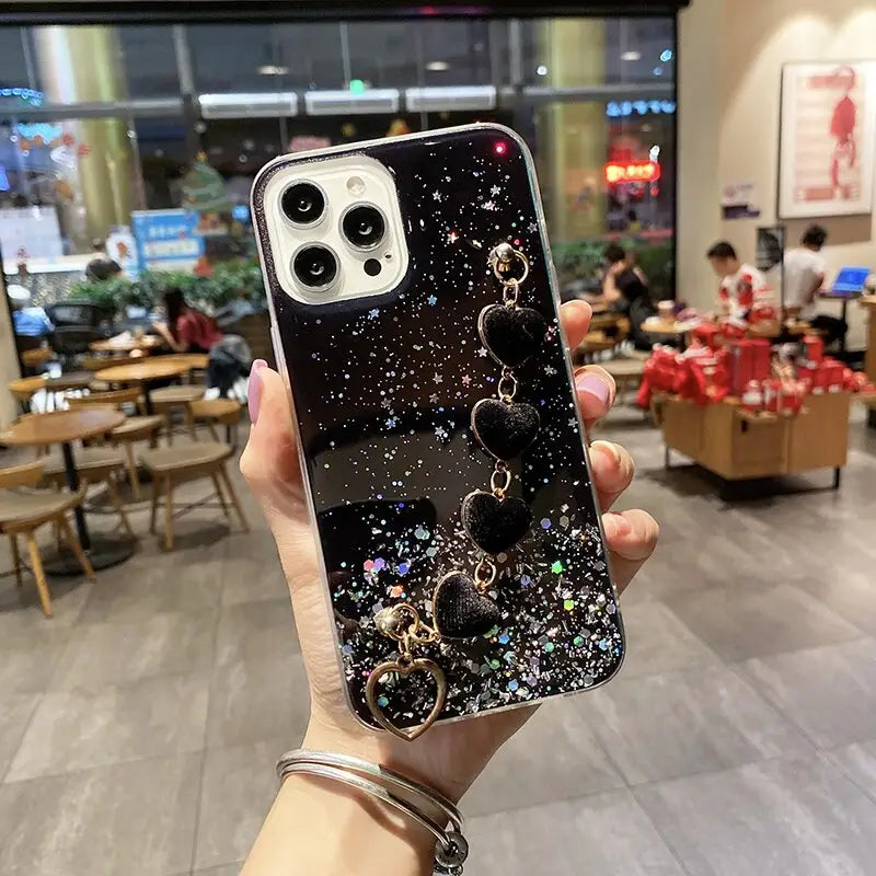 a woman holding up a phone case with a black and white glitter design