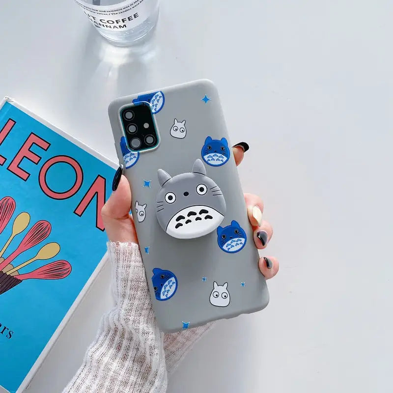 a person holding a phone case with a totoro design