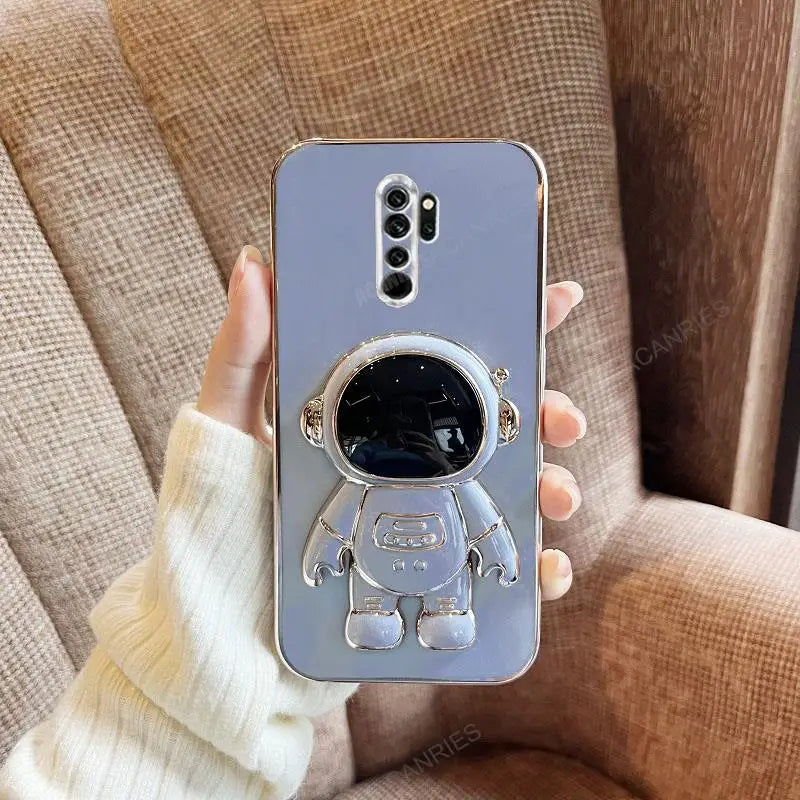 a person holding a phone case with a silver astronaut