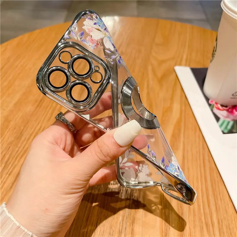 a hand holding a glass case with a flower design