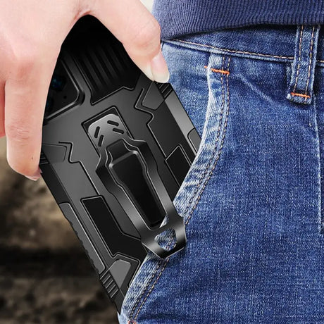 a hand holding a black phone case with a black phone in the back