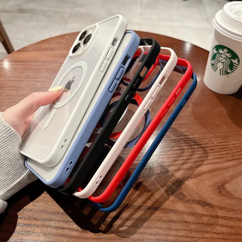 a person holding a phone case with a cup of coffee in the background
