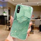 a person holding a phone with green marble