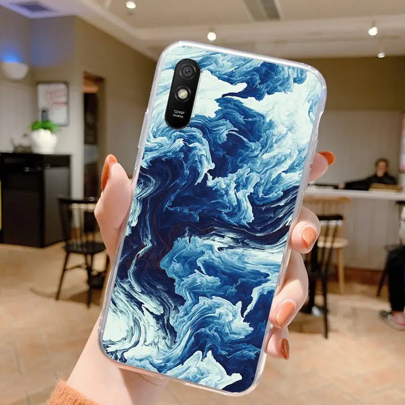 a woman holding up a blue marble phone case