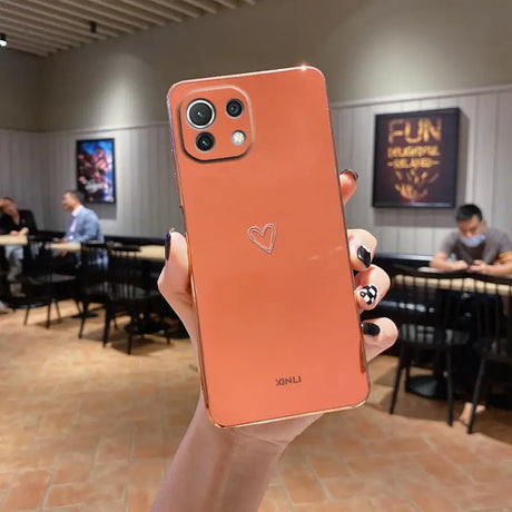 a person holding up a phone with a heart on it