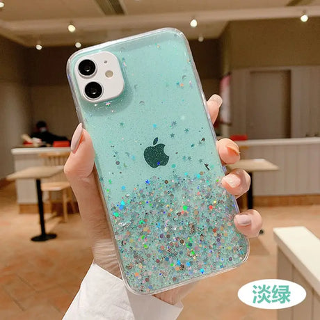 a woman holding up a phone case with glitter on it