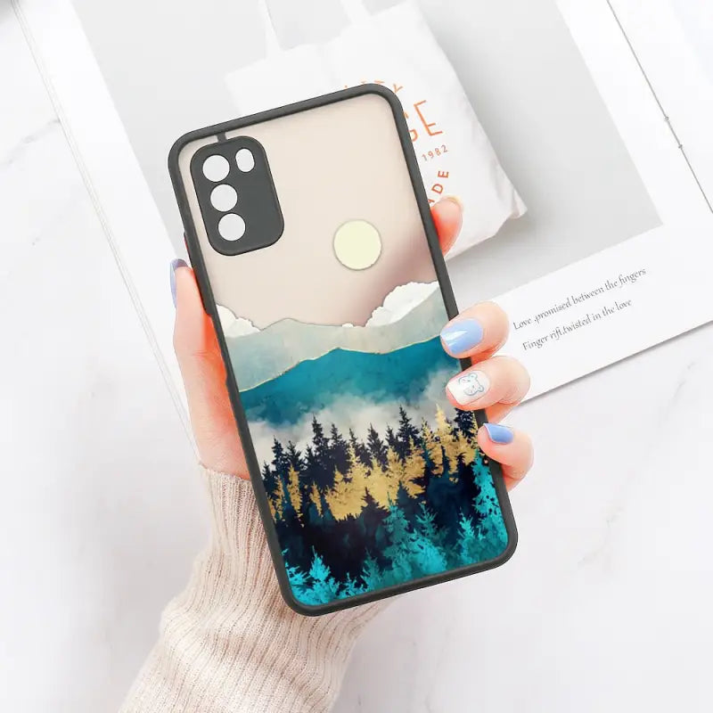 a woman holding a phone case with a forest scene