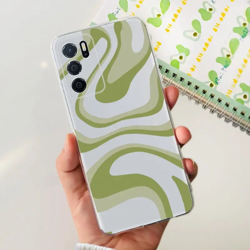 a person holding a phone case with a green and white pattern