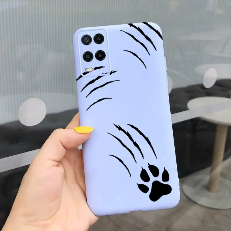 a hand holding a phone case with a cartoon face