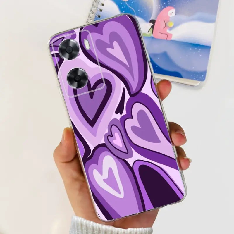 a person holding a phone case with a purple heart design