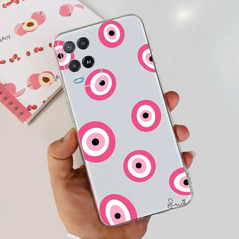 a person holding a phone with pink eyes on it