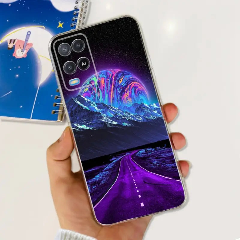 a hand holding a phone case with a purple and blue landscape