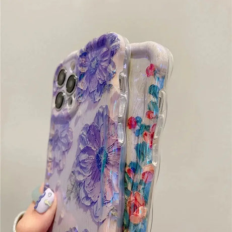 a woman holding a phone case with flowers on it