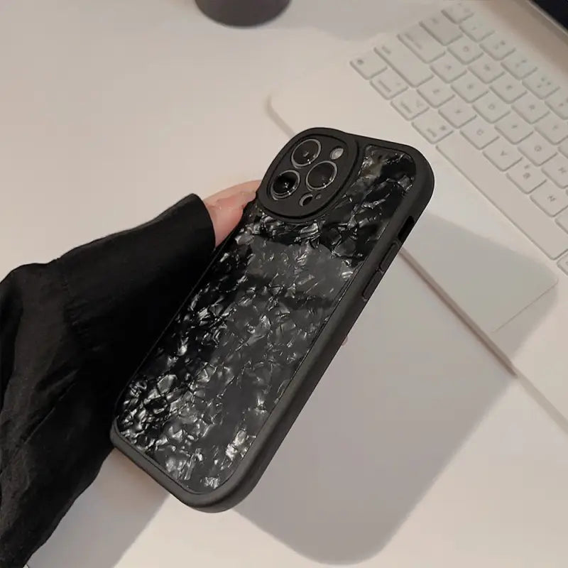 a person holding a phone with a broken screen