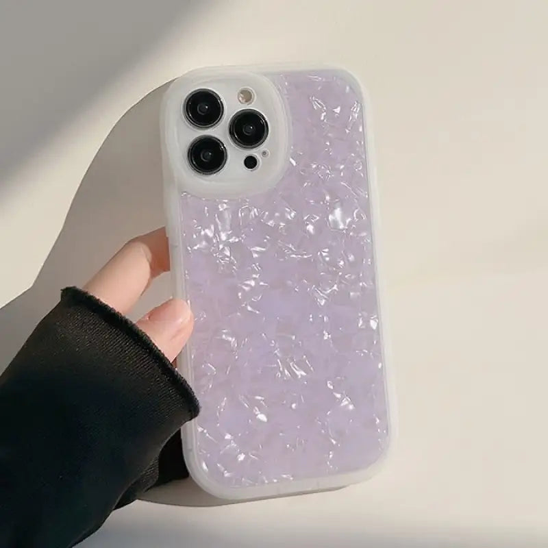 a person holding a phone case with a purple liquid