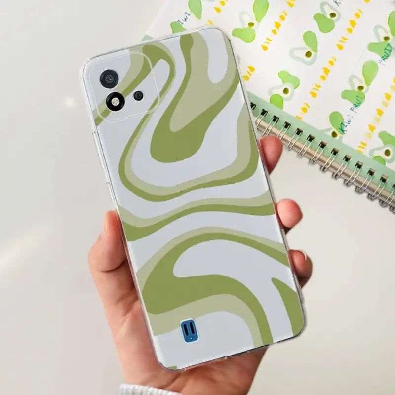 a person holding a phone with a green and white pattern