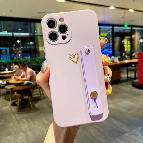 a woman holding a phone case with a heart on it