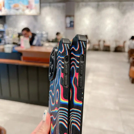 a person holding a phone with a colorful design on it