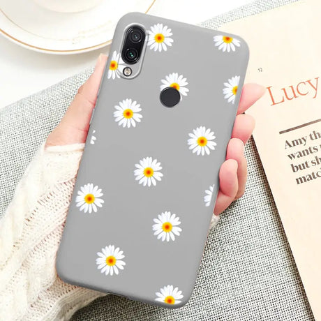 a close up of a person holding a phone with a flower pattern on it