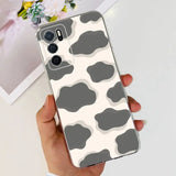 a woman holding a phone case with a cow print