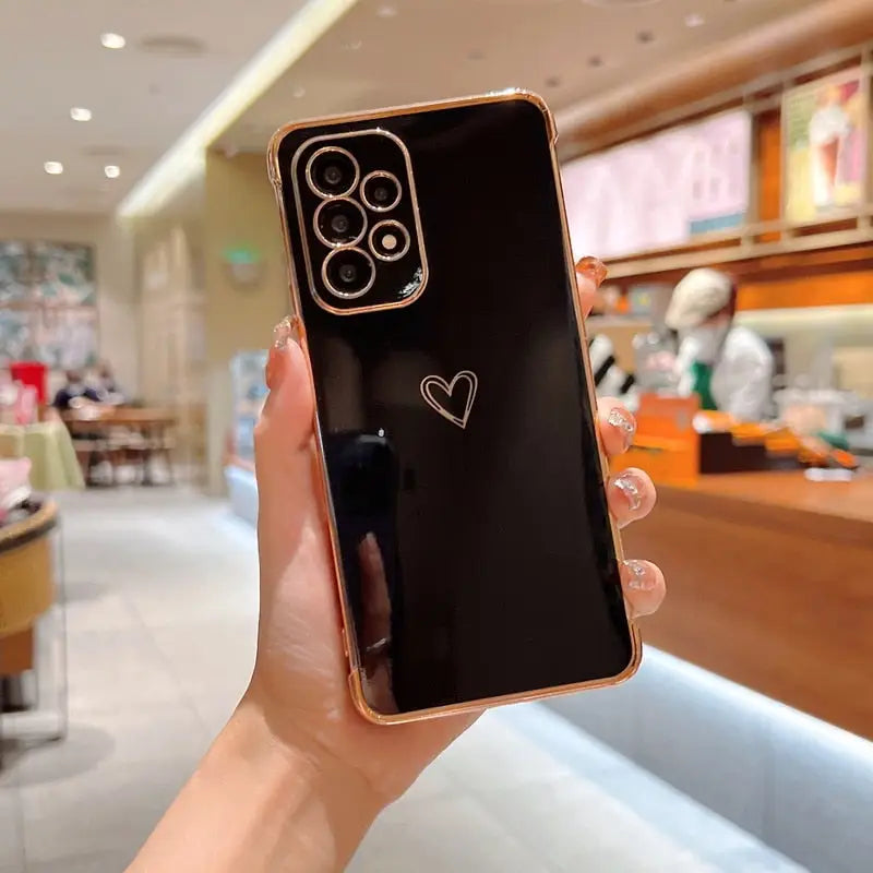 a person holding up a phone with a heart drawn on it