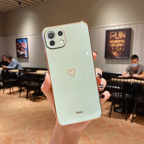 a person holding up a phone with a heart on it