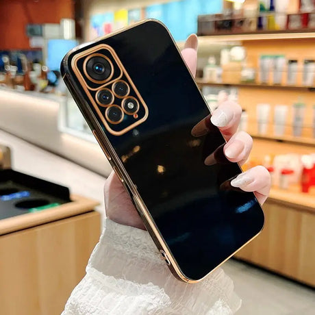 a woman holding up a black iphone case