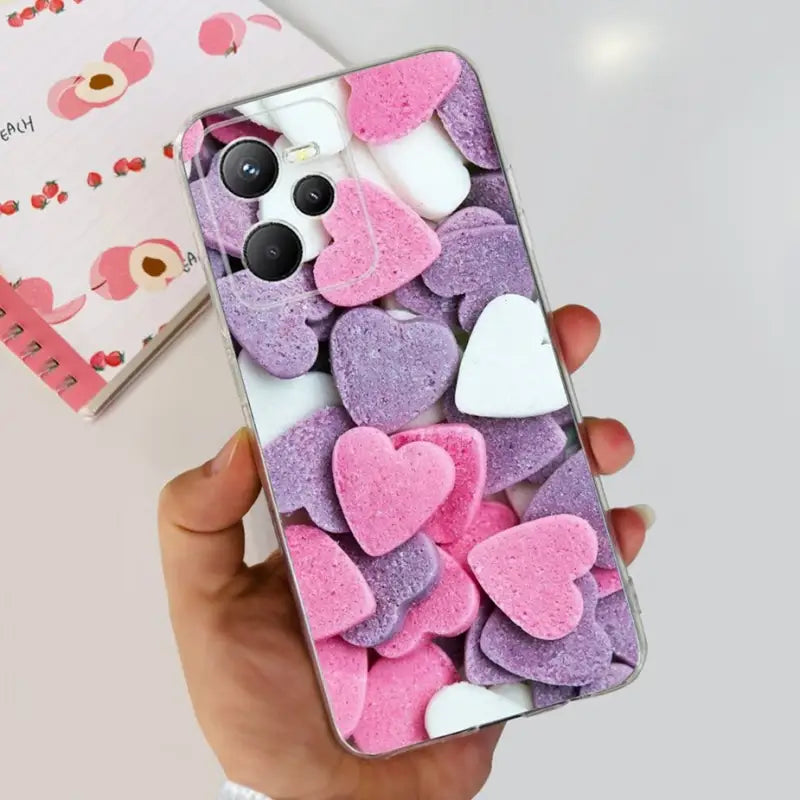 a person holding a phone with pink and white hearts