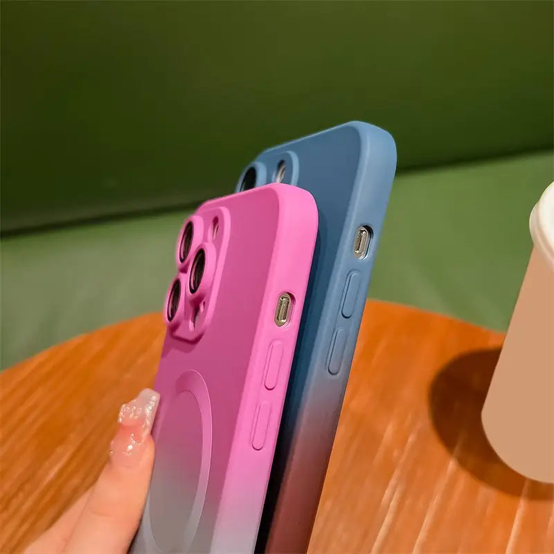 a person holding a phone with a pink and blue case