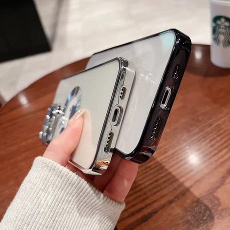 a woman holding a phone with a starbucks cup in the background