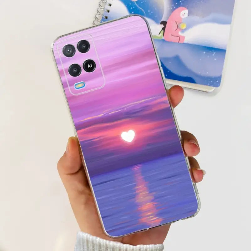 a person holding a phone with a sunset painting on it