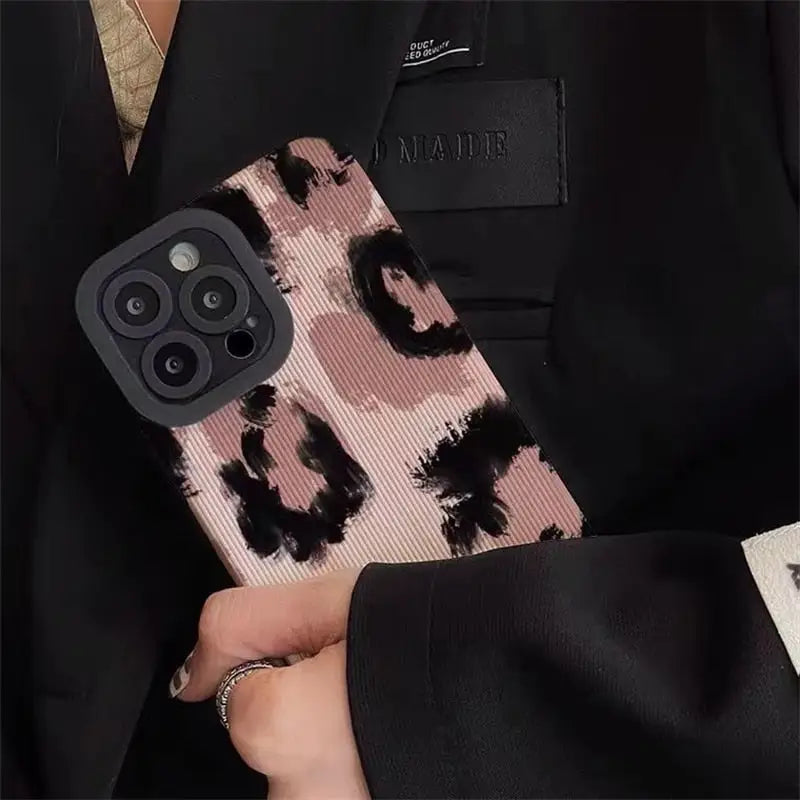 a person holding a pink and black phone case