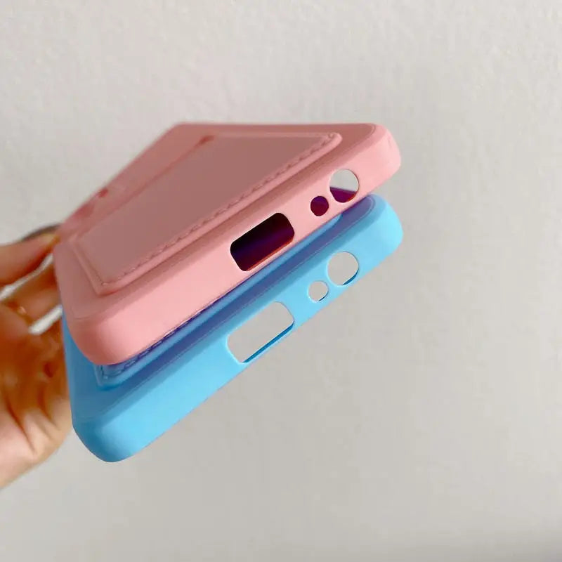 a hand holding a pink and blue phone