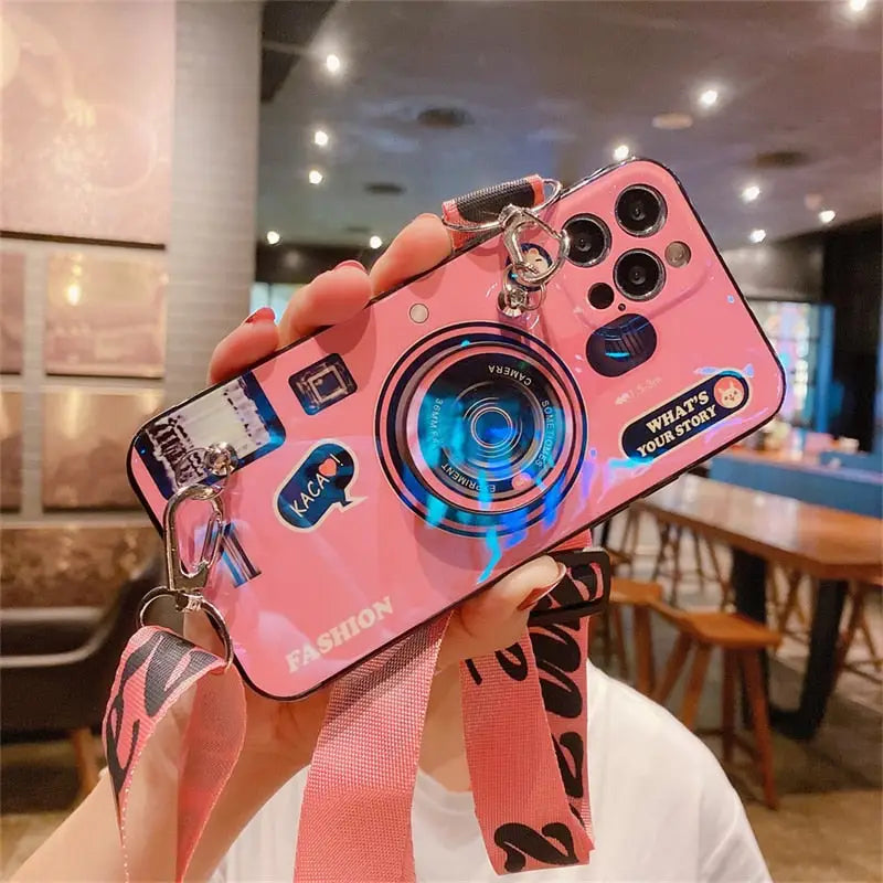 a woman holding up a pink camera