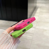 a person holding a pink and green phone