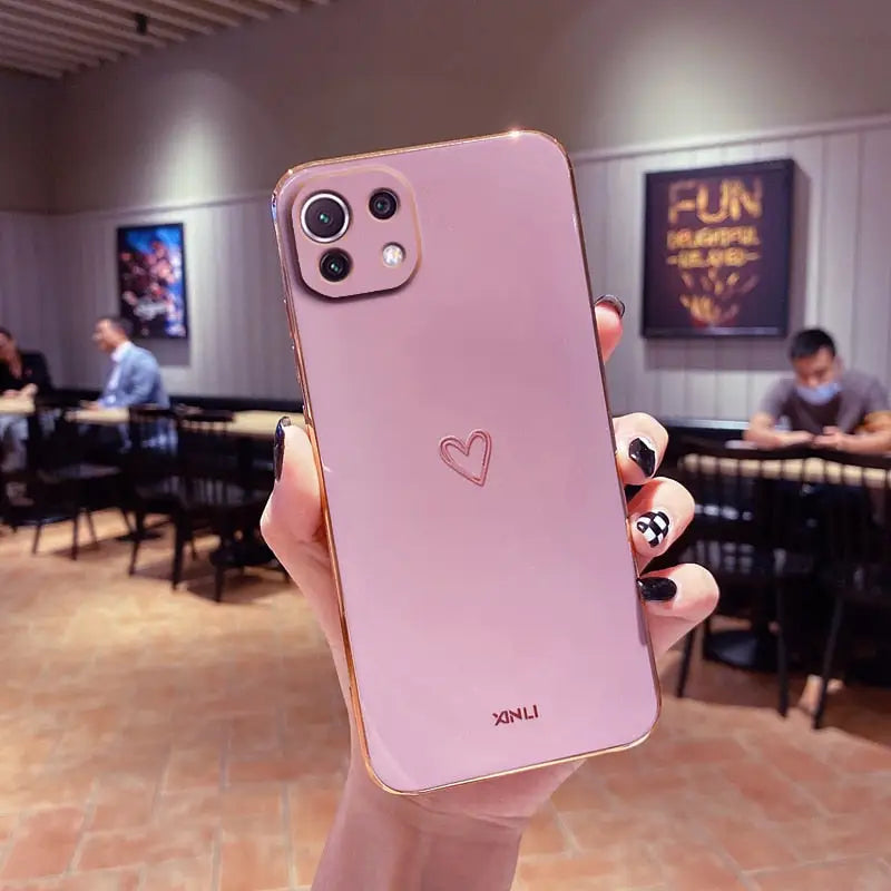 a person holding up a pink iphone case