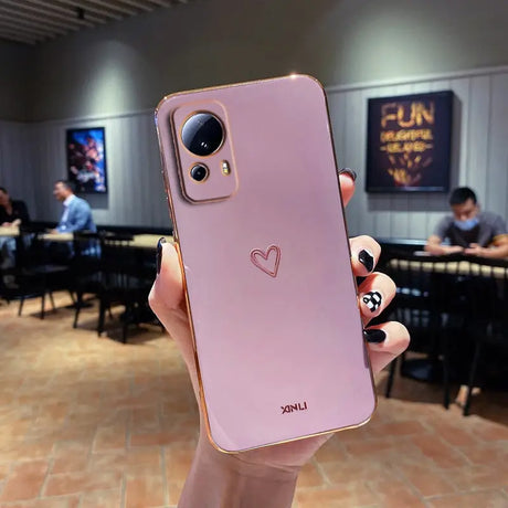 a person holding up a pink iphone case