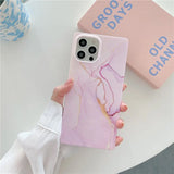 a person holding a pink marble phone case