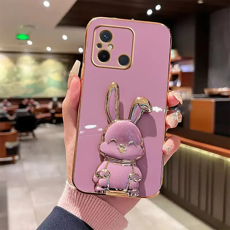 a woman holding a pink phone case with a rabbit on it