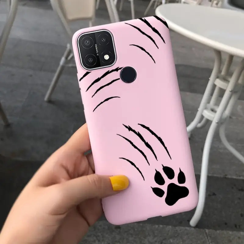a person holding a pink phone case with a black cat face on it