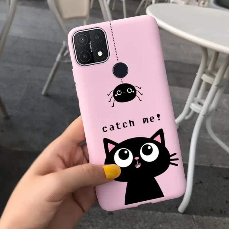 a person holding a pink phone case with a black cat on it