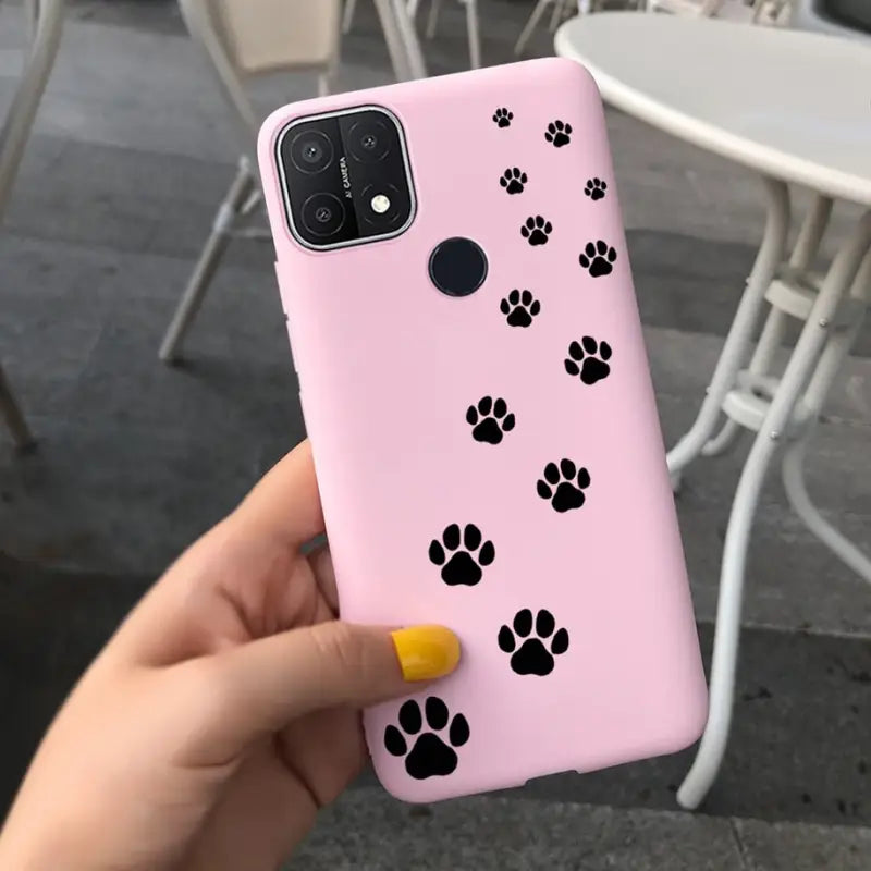 a person holding a pink phone case with paw prints