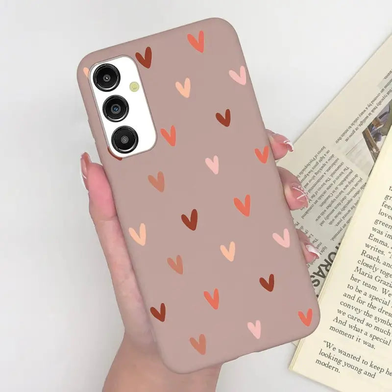 a woman holding a phone case with hearts on it