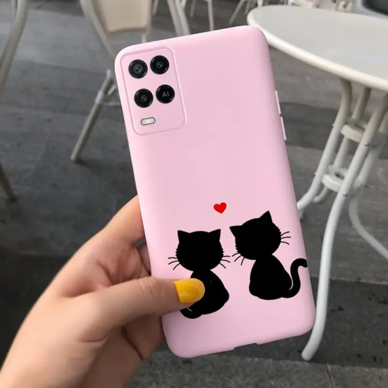 a person holding a pink phone case with a black cat and a heart