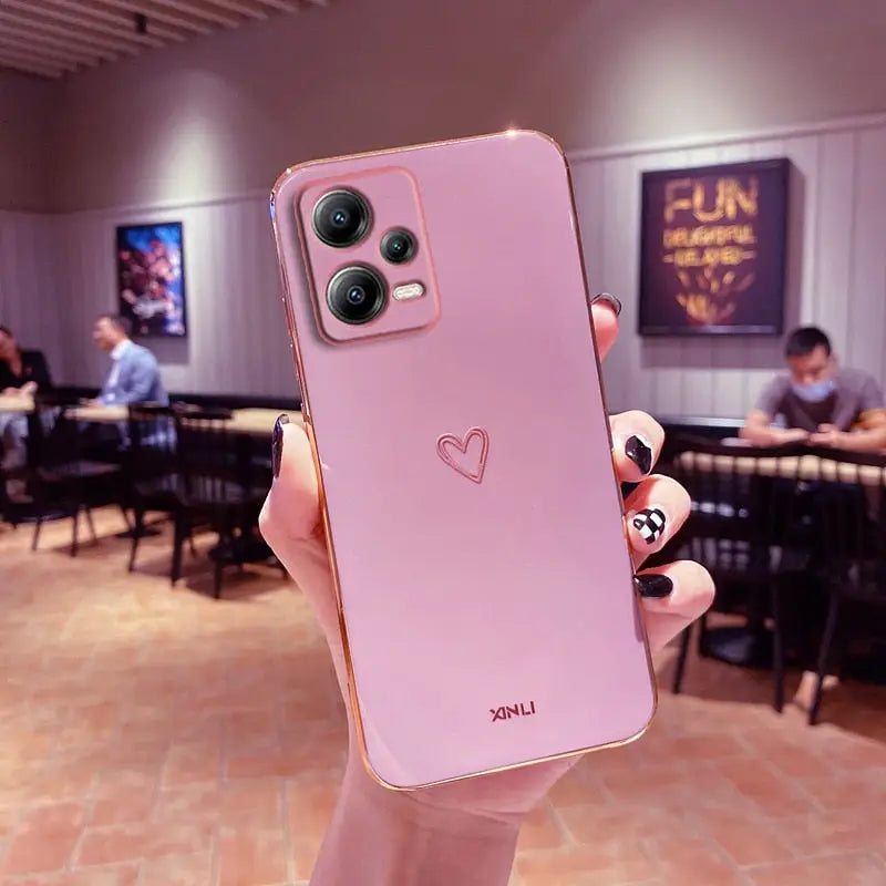 a person holding up a pink phone